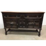 A 19th century oak dresser base with geometric carved doors and drop brass handles. W:153cm x D:53cm