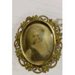 A late 19th/early 20th century portrait brooch with hand engraved and painted portrait of a lady