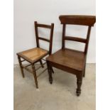 An oak seated dining chair and a rattan chair