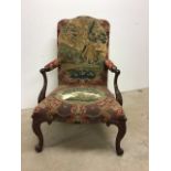 An early 19th century mahogany upholstered armchair on carved scrolling feet with 19th century