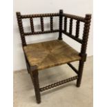 An antique bobbin turned corner chair with wicker seat W:41cm x D:41cm x H:62cm