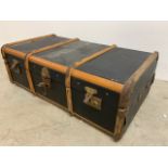 A travelling trunk, canvas and bent wood exterior with metal bound edges W:92cm x D:54cm x H:30cm