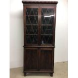 A Georgian mahogany two part bookcase. Beaded cornice over two glazed door with velvet lined