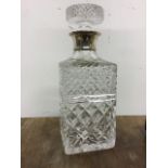 A sterling silver collared moulded glass decanter. 26cm(h)