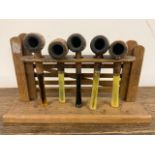 An oak pipe rack with five pipes W:28cm x D:7cm x H:16cm