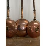 Three copper warming pans. W:30cm x D:10cm x H:113cm