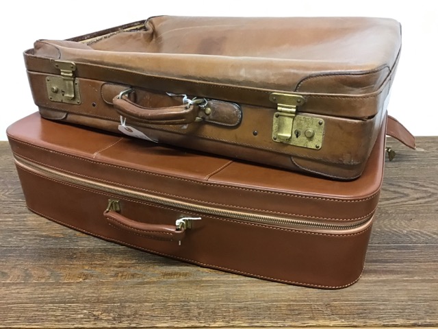 A vintage leather suitcase and another