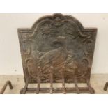 A Victorian fire back depicting an eagle in the sun also with a fire grate and dogs. W:48cm x D:cm x
