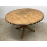 A pine circular kitchen table on turned quatrefoil base.