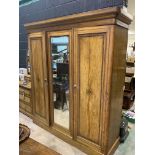 A continental painted pine triple wardrobe with painted details and bevelled mirror.