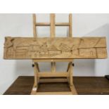 Wooden carved panel depicting a village scene. W:76cm x D:4cm x H:16cm