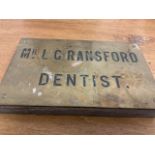 A brass dentistâ€™s plaque on oak panel. W:20.5cm x D:2.5cm x H:13cm