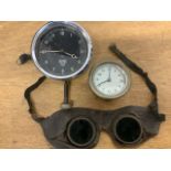 A pair of early leather goggles together with a Smiths clock and another.