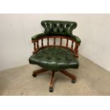 A revolving captains office chair in green leather W:64cm x D:64cm x H:79cm