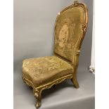 An early 19th century gilt gesso mahogany upholstered chair on scrolling cabriole legs. With