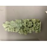 A large piece of pale green jade carved with an Oriental scene depicting flowers and trees. In