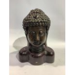 A bronze Buddha head on wooden base. 23cm(h)