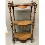 A decorative 19th century three tier what not with serpentine inlaid shelves, turned legs to ceramic