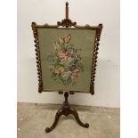 An adjustable antique walnut fire screen with embroidery floral subject flanked by turned columns