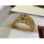 An 18k gold and diamond dress ring central bezel set diamond approximately 5mm with a surround of