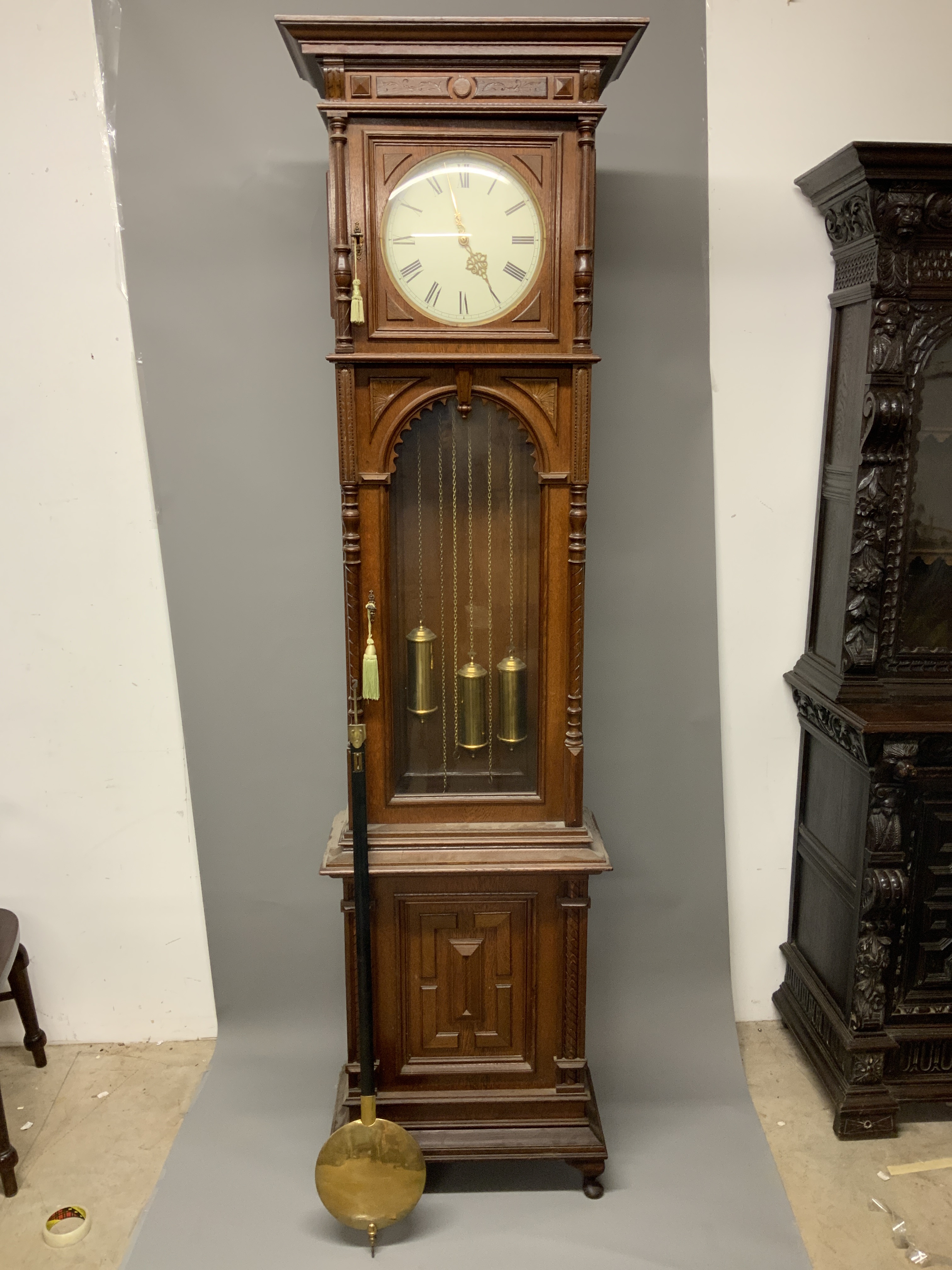 A large 20th century oak longcase clock, the case with arched glazed door. Triple weight chiming