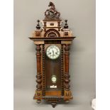 A Vienna style wall clock with pendulum and key. 106cm(h)