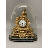 A french gilt mantle clock in glass dome on oval wooden base. W:36cm x D:16cm x H:43cm