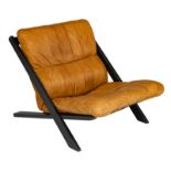 A black-painted wooden lounge chair with tan leather upholstery, design by Ueli Berger for De Sede,