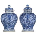 A pair of Chinese blue and white floral decorated vases and covers, with a four-character mark, 19th