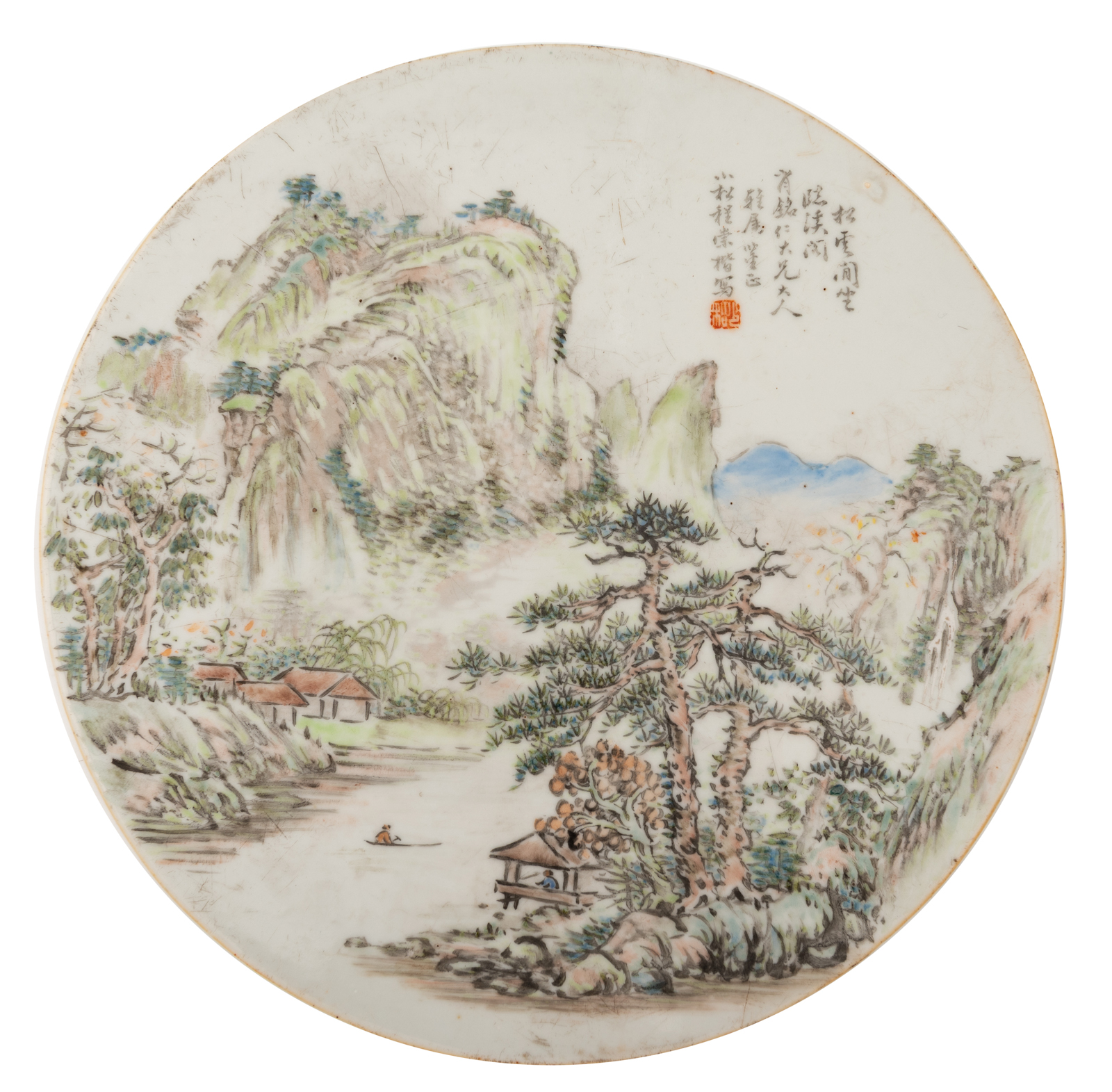 A Chinese polychrome porcelain round plaque, decorated with figures in a mountainous river landscape