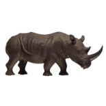 A fine realistic wooden carved sculpture of a rhino, dark polychrome painted, H 31,5 - W 70,5 cm
