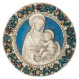 A polychrome decorated plaster tondo depicting the nursing Madonna in a flower wreath, in the manner
