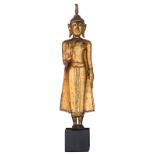 An Oriental gilt decorated bronze figure, depicting a standing Buddha, the raised right hand in abha