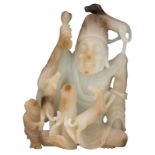 An Oriental jade and coloured jade carved figure, holding a bone and surrounded by a child and three