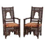 A pair of Moorish inspired richly sculpted rosewood armchairs, decorated with mother-of pearlinlay a