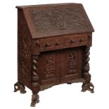 An Anglo-colonial exotic hardwood fall front desk, richly carved with Buddhistic ornaments, the top