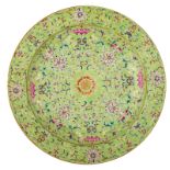 A Chinese lime green ground and famille rose plate, both sides decorated with flowers, bats, fruits