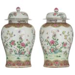 A pair of large famille rose vases and covers, decorated with flowers, insects and birds on flower b