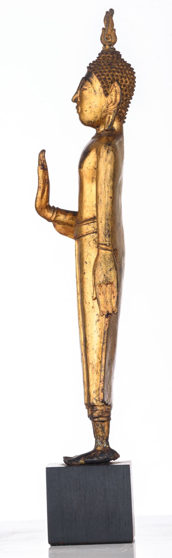 An Oriental gilt decorated bronze figure, depicting a standing Buddha, the raised right hand in abha - Image 3 of 5