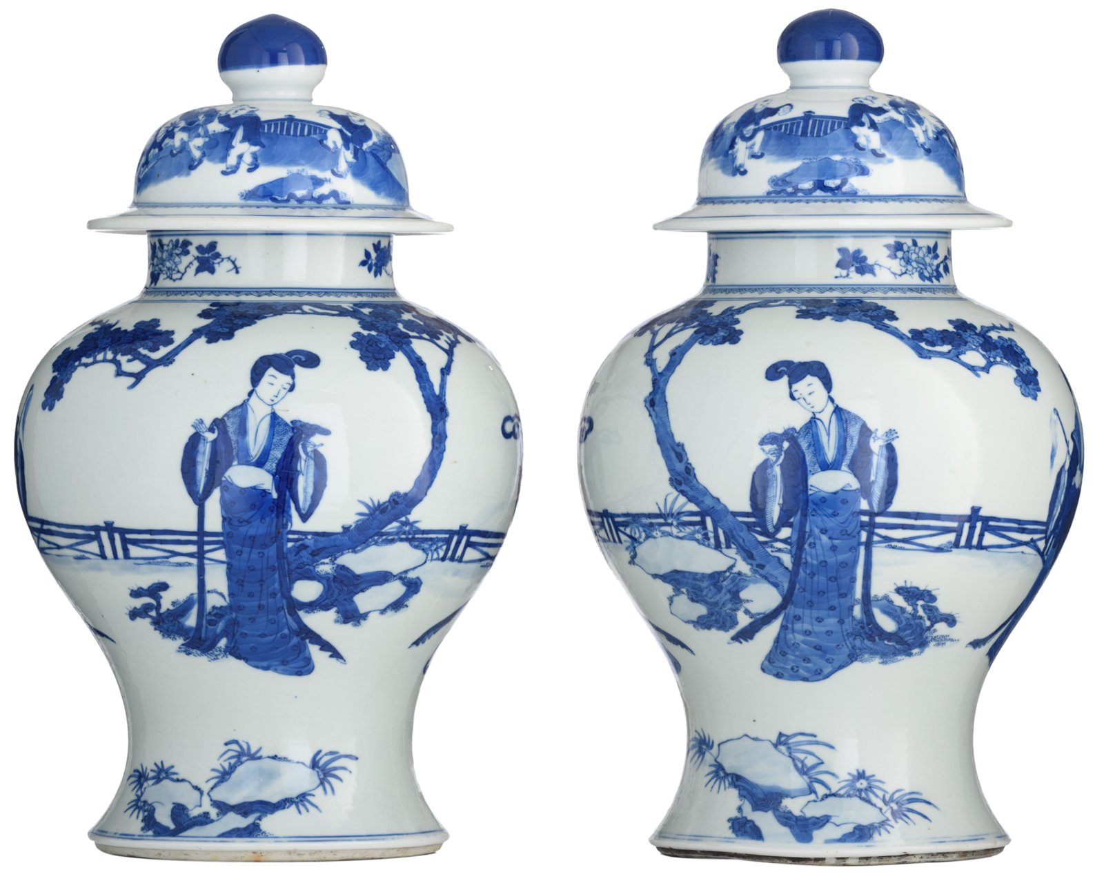 A pair of Chinese blue and white vases and covers, decorated with beauties in a garden setting, 19th