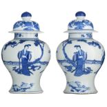 A pair of Chinese blue and white vases and covers, decorated with beauties in a garden setting, 19th