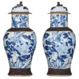 A pair of Chinese blue and white stoneware vases and covers, decorated with flowers and birds, marke
