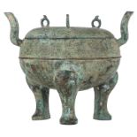 A Chinese bronze ritual tripod food vessel and cover, decorated with dragon-scroll pattern and archa