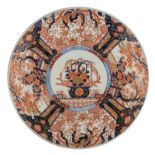 A large Japanese Arita Imari plate, the centre decorated with a flower basket, the roundels with ter