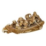 An ivory okimono (netsuke) depicting the seven Gods of Fortune in their treasure ship, with black st