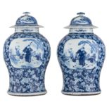 A pair of Chinese floral decorated blue and white vases and covers, the roundels with animated scene