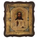 An Eastern European icon representing Christ with a gilt silver oklad and partially enamelled frame,