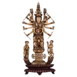 A Chinese patinated ivory carved group, depicting a multi-armed goddess, on a matching wooden base,