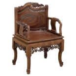 A Chinese inspired richly sculpted hardwood armchair, the backrest depicting dragons and birds, sitt