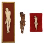 Three finely carved Corpus Christi sculptures, one in pine and two in ivory on a silk and velvet uph